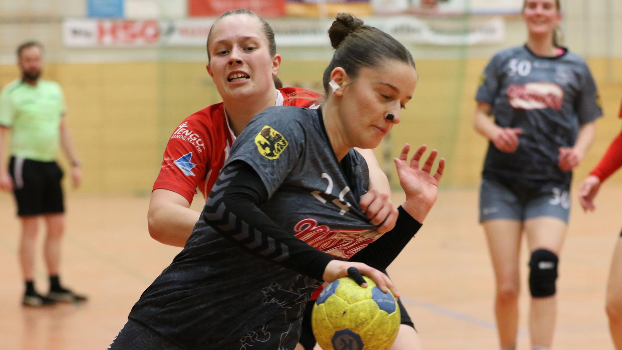 Die Abwehrspielerin hält Marei Nuss am Trikot fest.