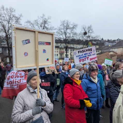 Menschen halten Protestplakate auf dem Overather Bahnhofplatz in die Höhe