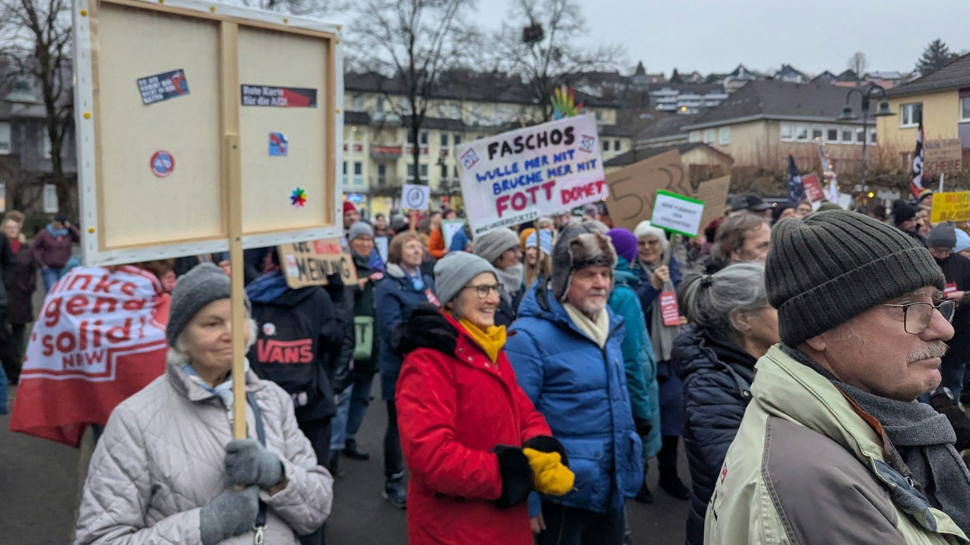 Menschen halten Protestplakate auf dem Overather Bahnhofplatz in die Höhe