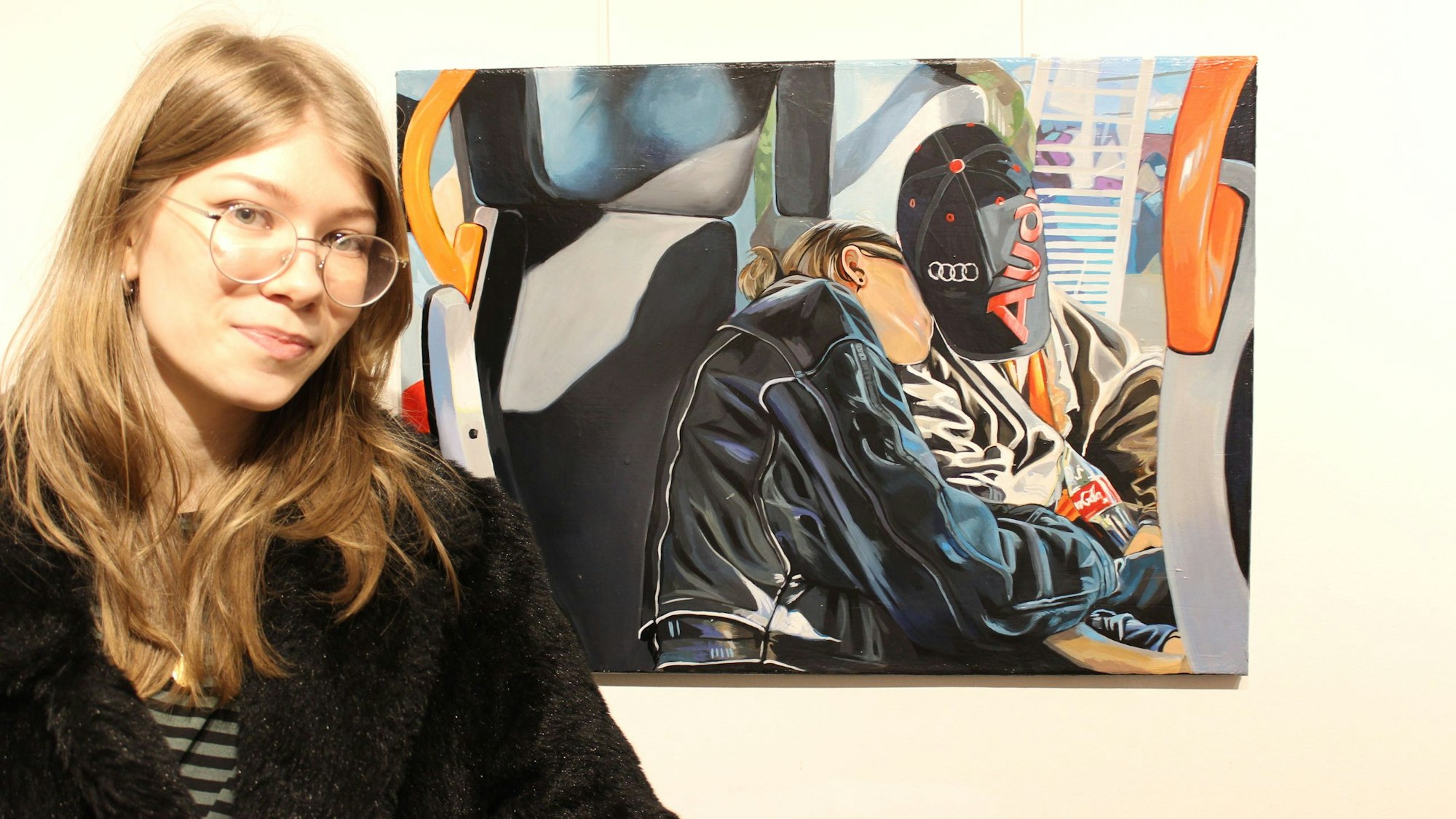 Zu sehen ist eine junge Künstlerin vor ihrem Gemälde.