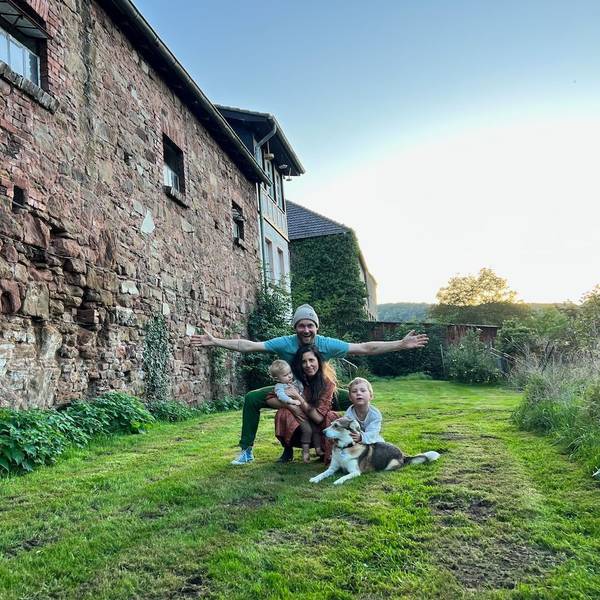 Die Familie und der Hund vor dem Außengemäuer der Burganlage.