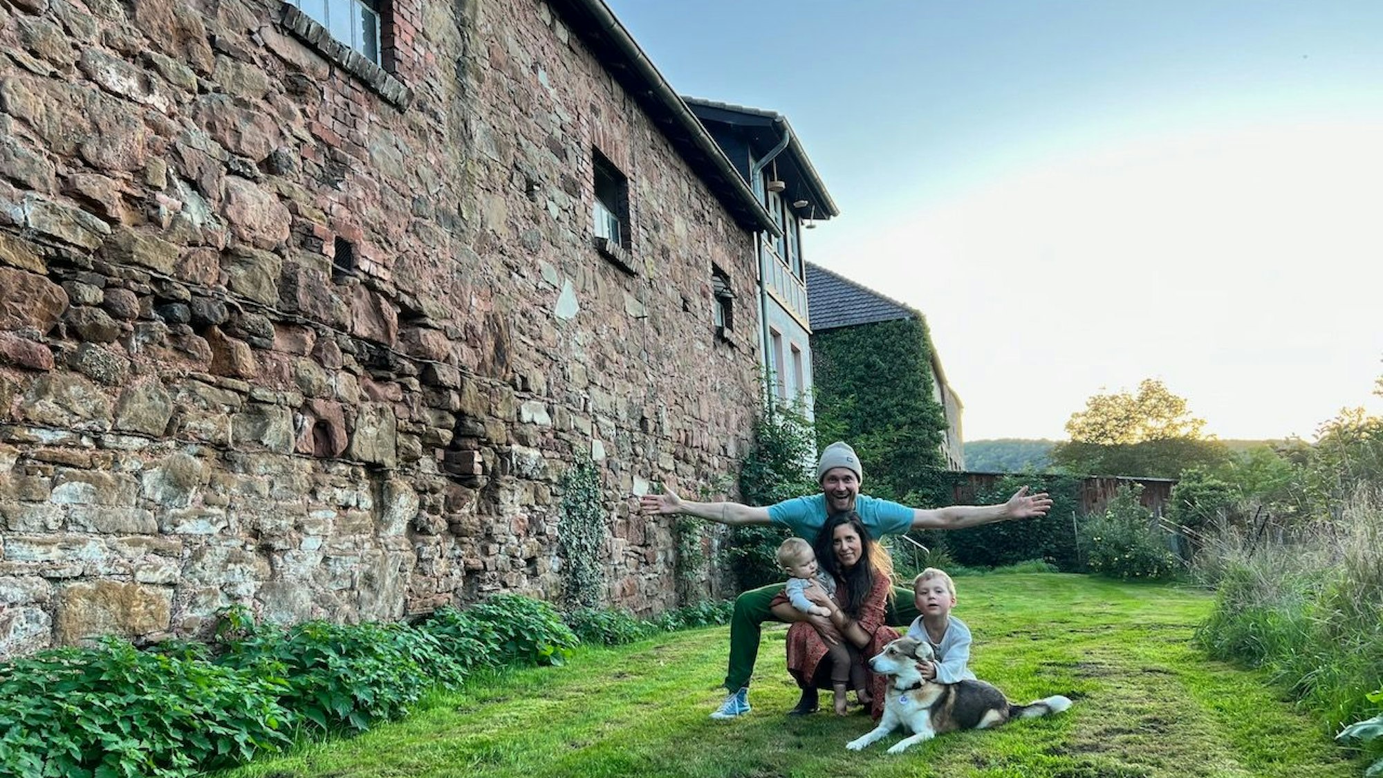 Die Familie und der Hund vor dem Außengemäuer der Burganlage.