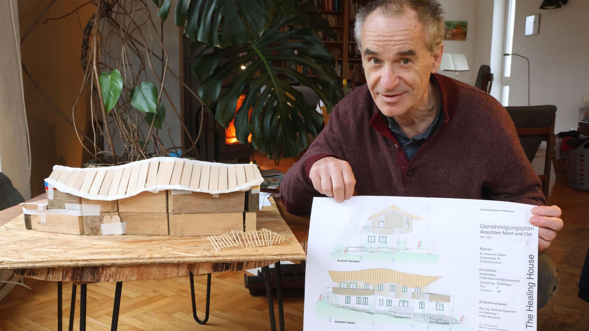 Das Foto zeigt Ruprecht Olbeter mit einem Modell und einer Zeichnung des geplanten Praxisneubaus, das in Reichshof-Brüchermühle entstehen soll.