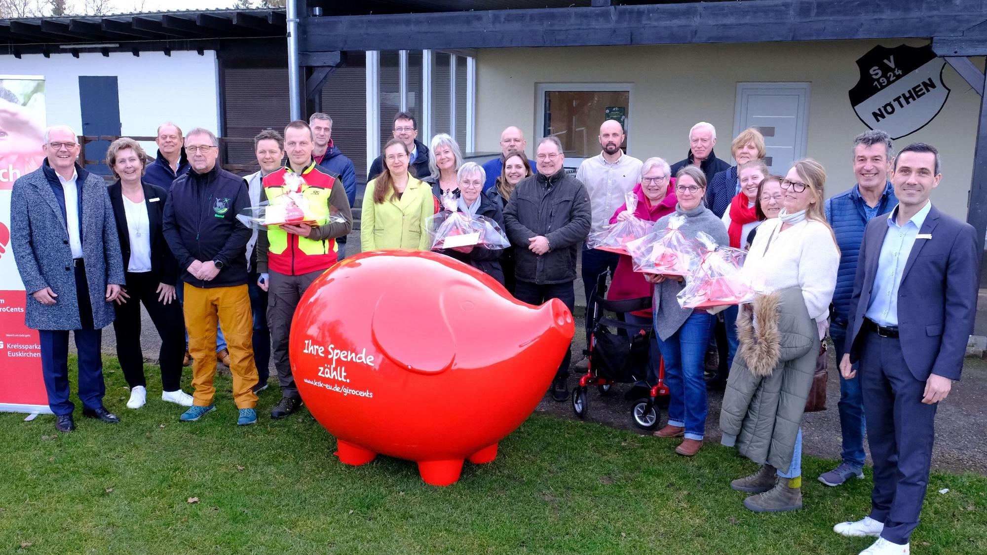 Vertreter verschiedenen Vereine und der Kreissparkasse Euskirchen beim Gruppenbild mit einem überdimensionierten Sparschwein.