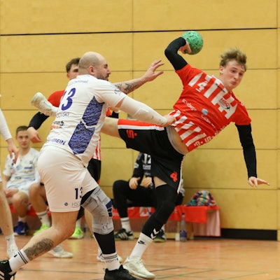 Merlin Klocker beim Wurf. Ein Gegenspieler greift mit dem rechten Arm nach dessen Trikot.