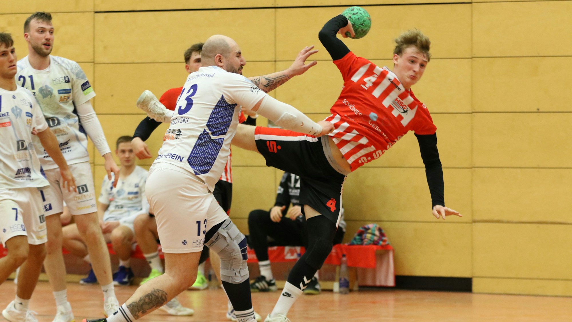 Merlin Klocker beim Wurf. Ein Gegenspieler greift mit dem rechten Arm nach dessen Trikot.