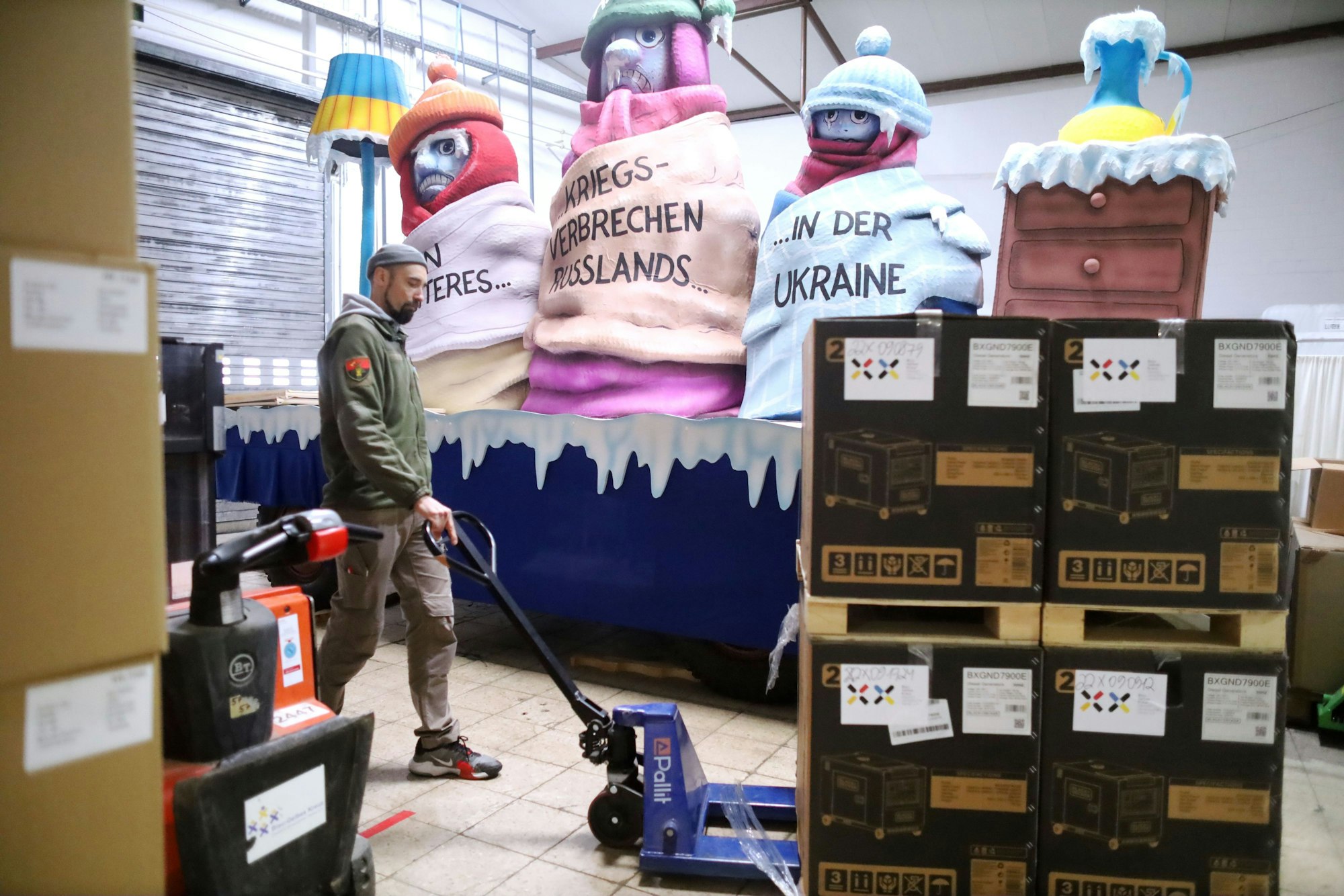 Roman, Leiter der Lagerhalle des Blau-Gelben Kreuzes, zeigt die Palette mit Stromgeneratoren, die bereit für die Fracht ist.