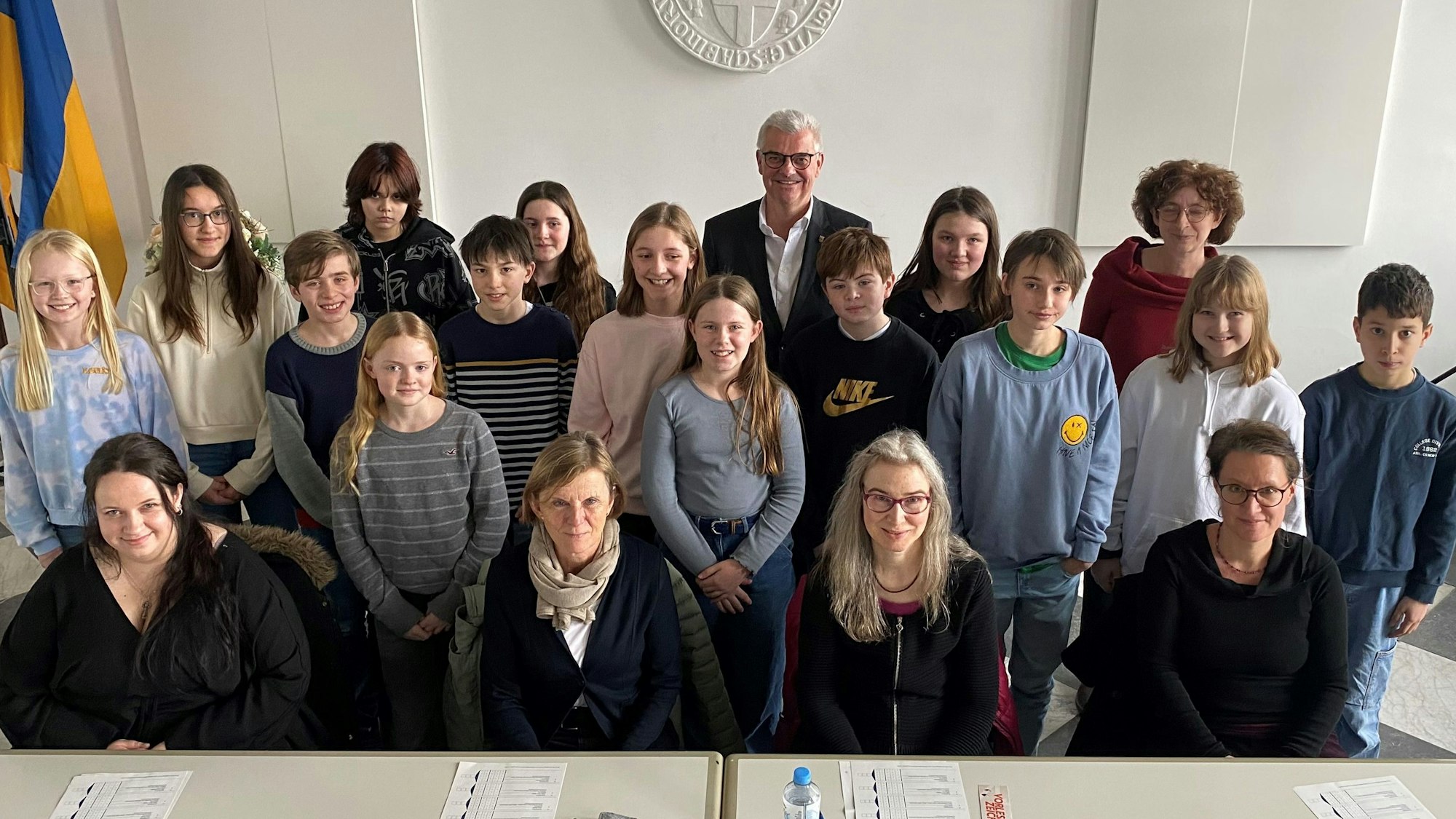 Kinder und Erwachsene lächeln in die Kamera.