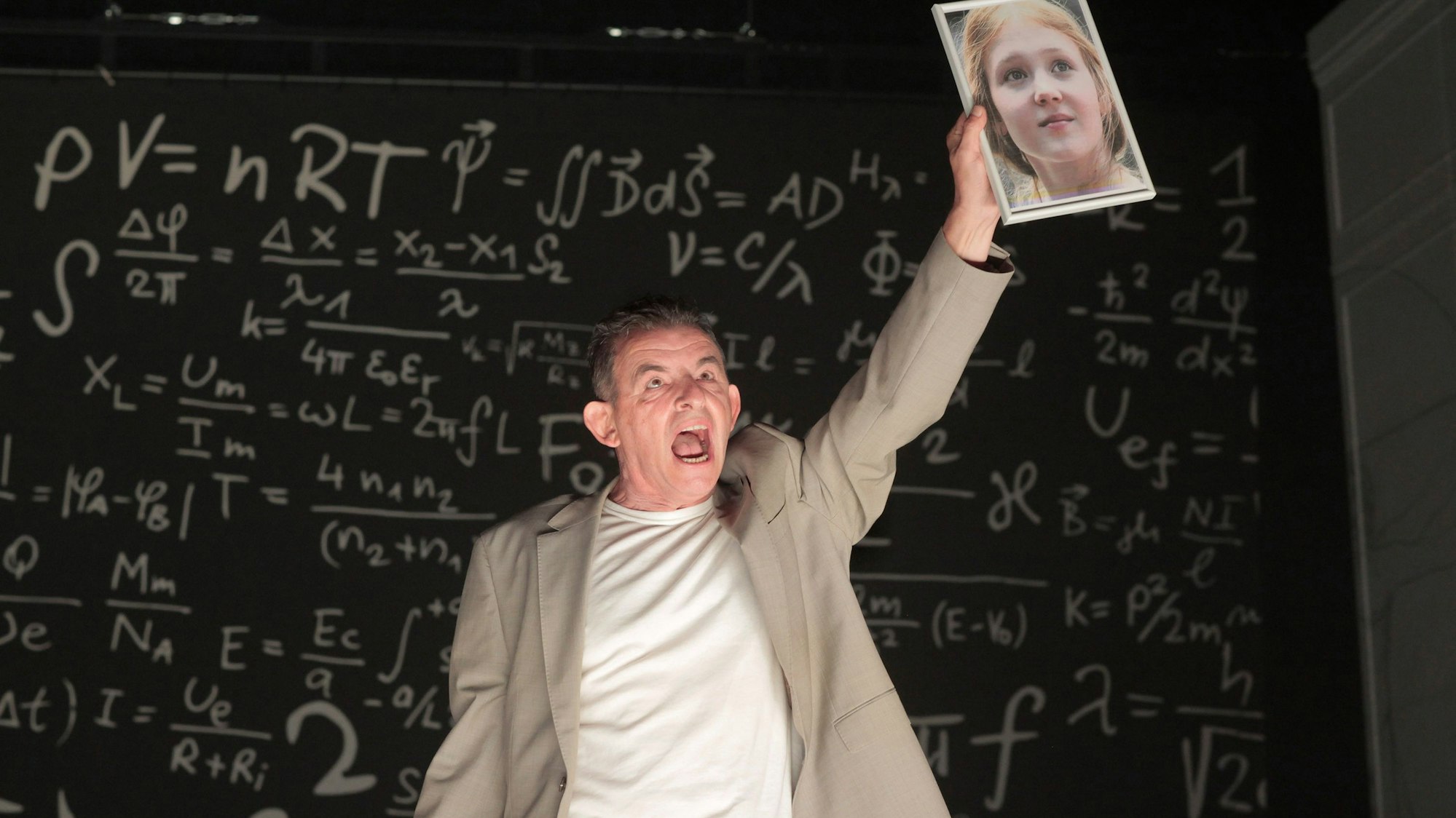 Auf dem Bild ist ein Schauspieler auf der Bühne zu sehen.