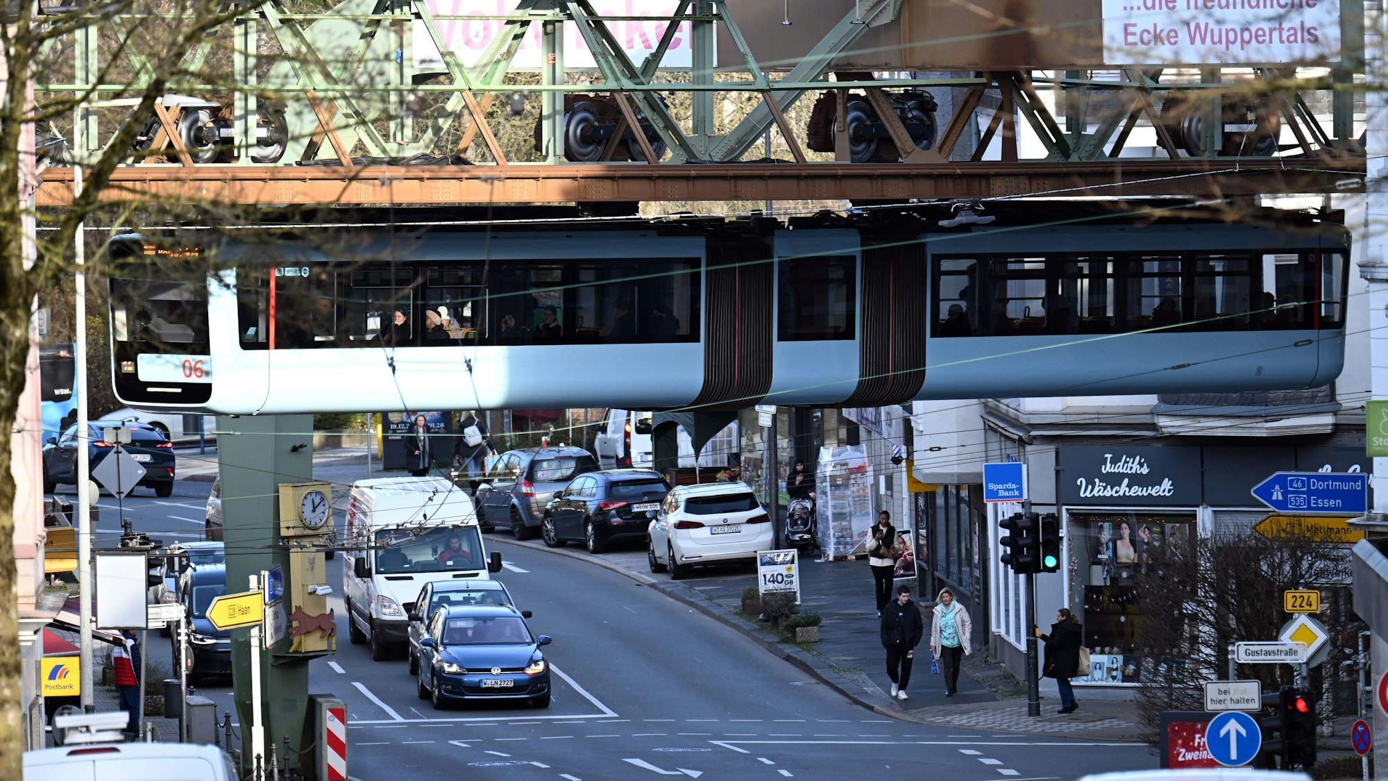 Ein Wagen der Schwebebahn fährt über dem Straßenverkehr. (Symbolbild)