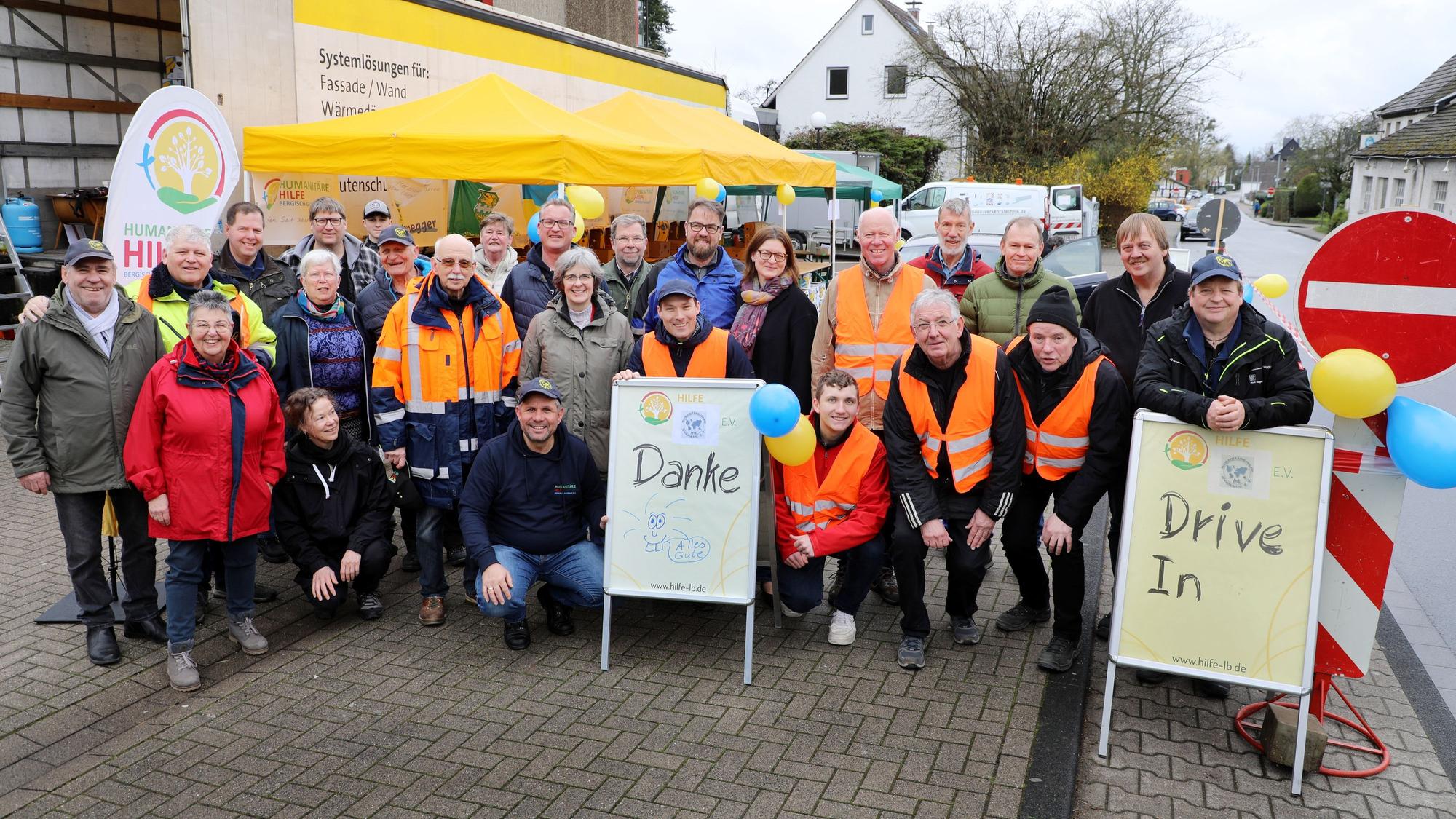 Vertreter von Humanitärer Hilfe Bergisch Gladbach und Humanitärer Hilfe Overath stehen an einem Spenden-Drive-In an der Kaule in Bensberg.