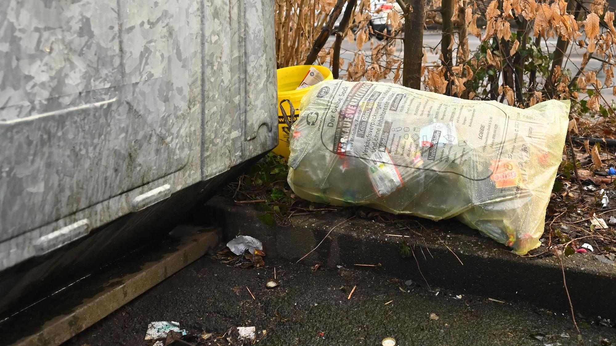 Das Bild zeigt Unrat neben einem Glascontainer.