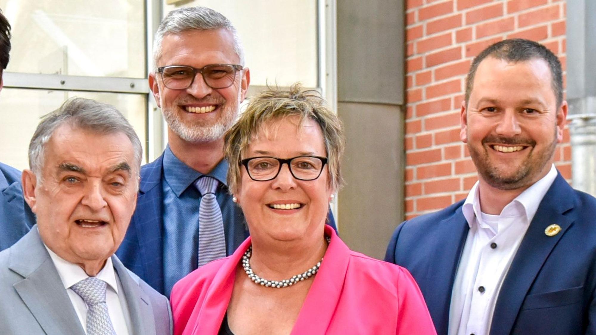 Das Foto zeigt drei Männer und eine Frau.