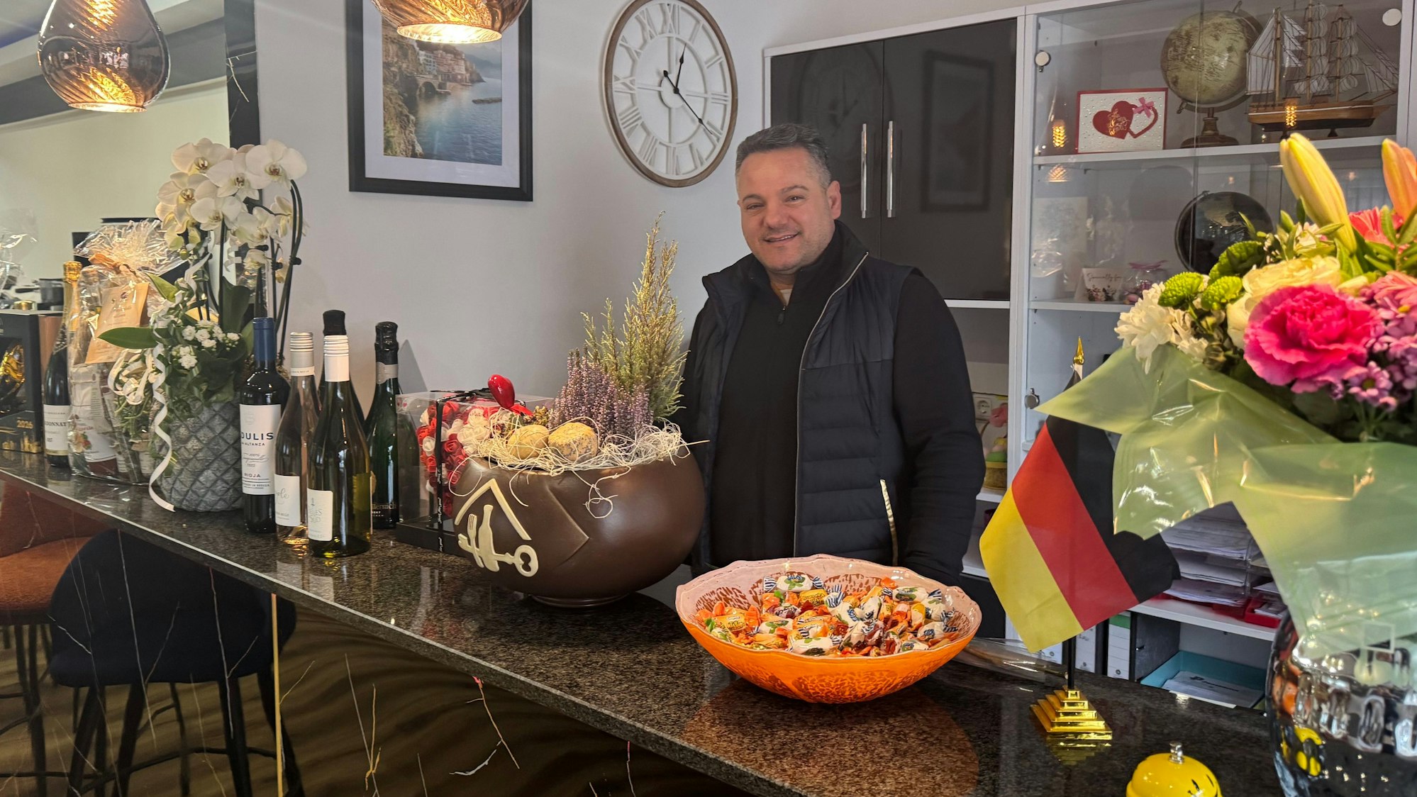 Auf dem Bild ist ein Mann hinter einem Tresen zu sehen.