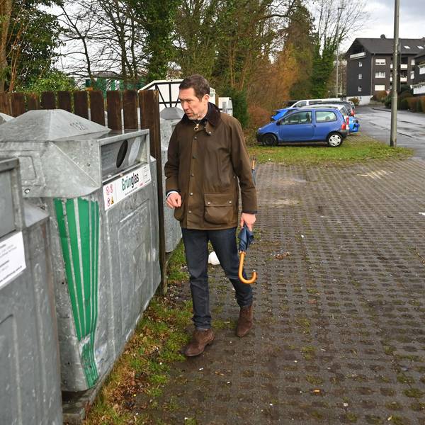 Das Bild zeigt den Gummersbacher Bürgermeister an einem Glascontainer.