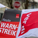 Eine Fahne der Gewerkschaft Verdi weht vor einem Stoppschild. (Archivbild)