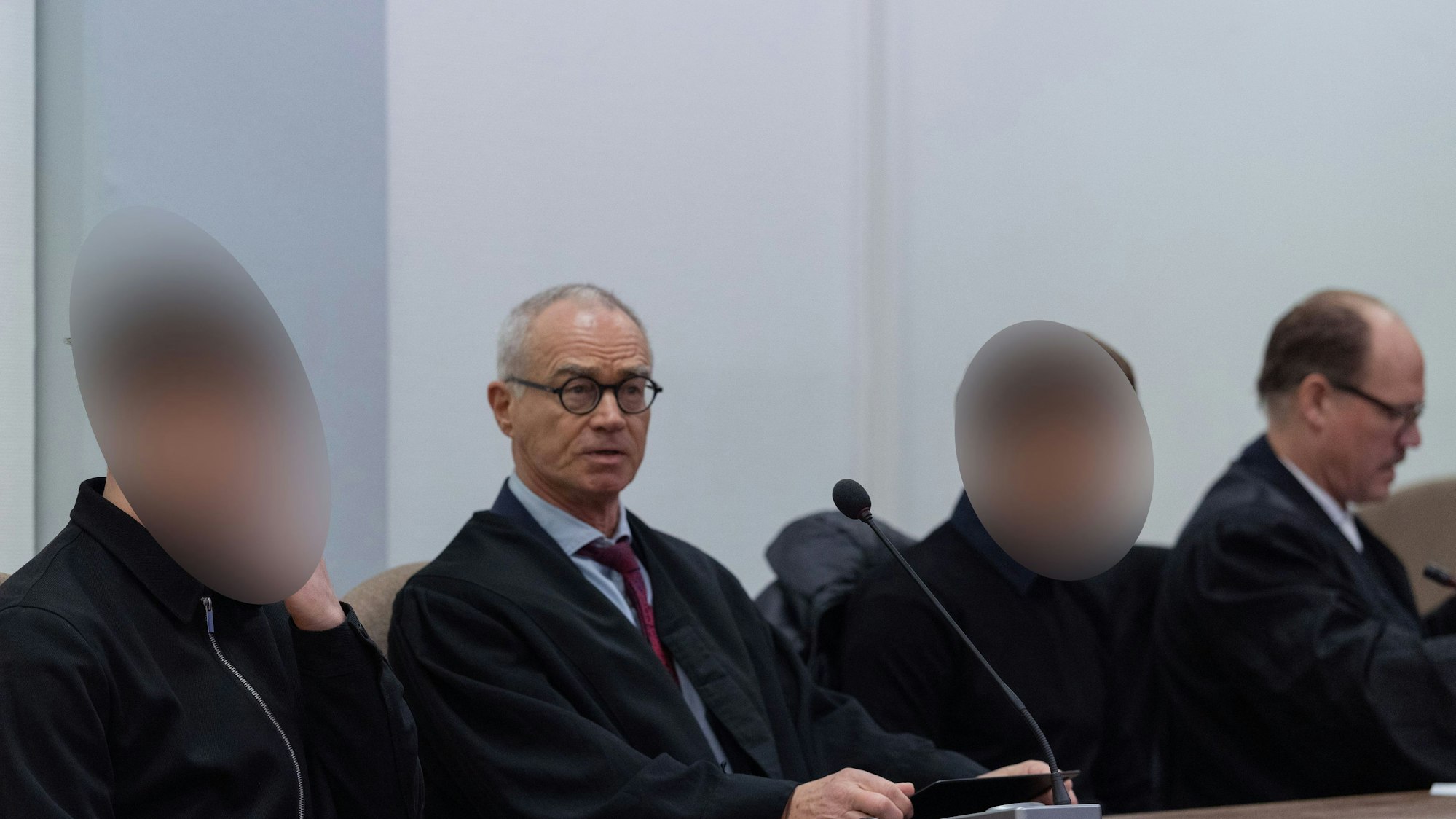 Die beiden Angeklagten sitzen im Landgericht Köln neben ihren Anwälten.