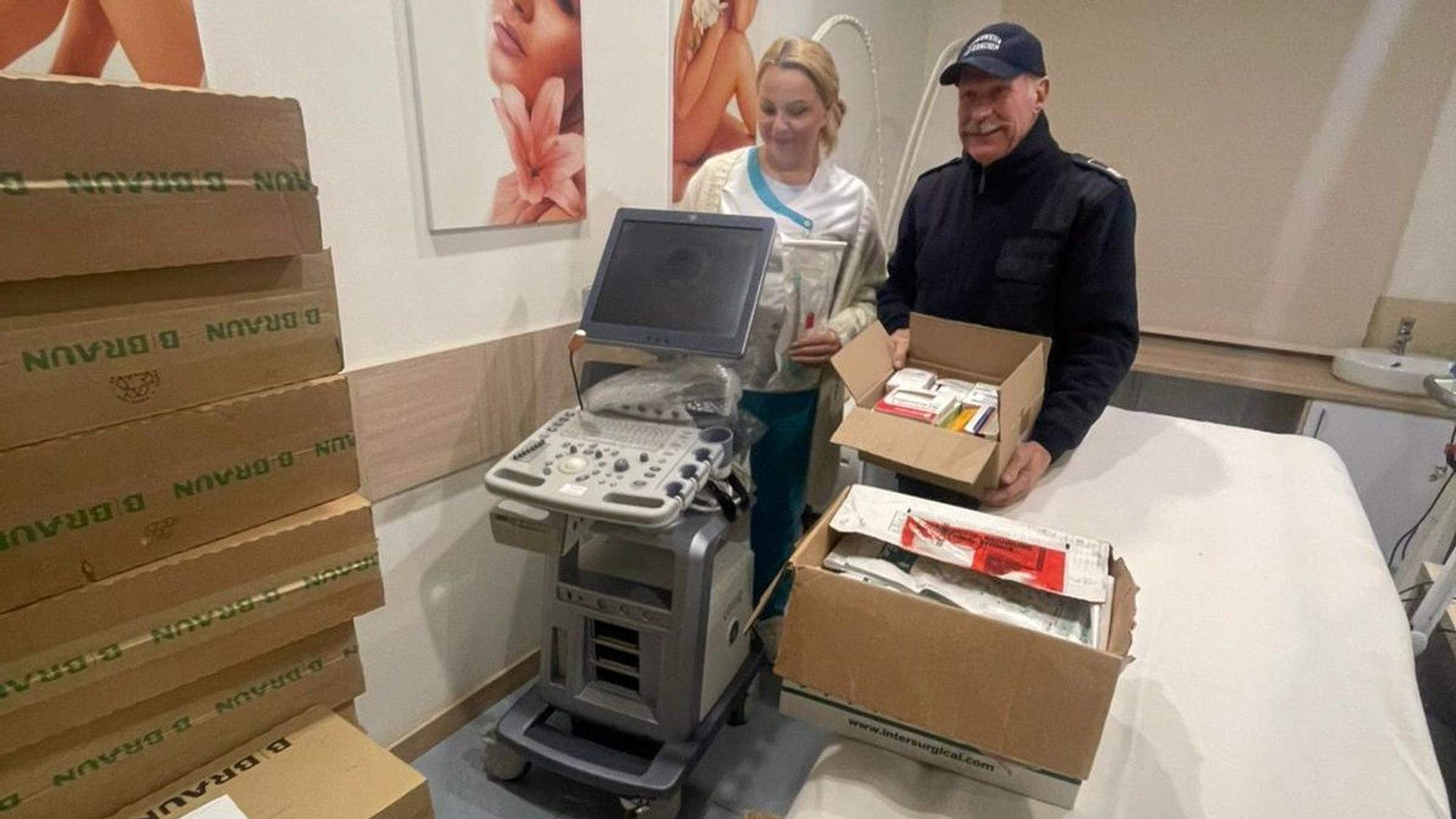 Gerd Kortschlag steht mit einer Klinikmitarbeiterin neben einem Ultraschallgerät.