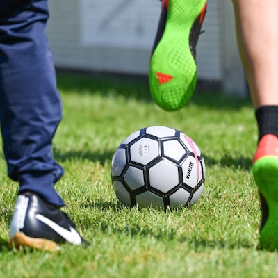 Kinder spielen auf einem Sportplatz.