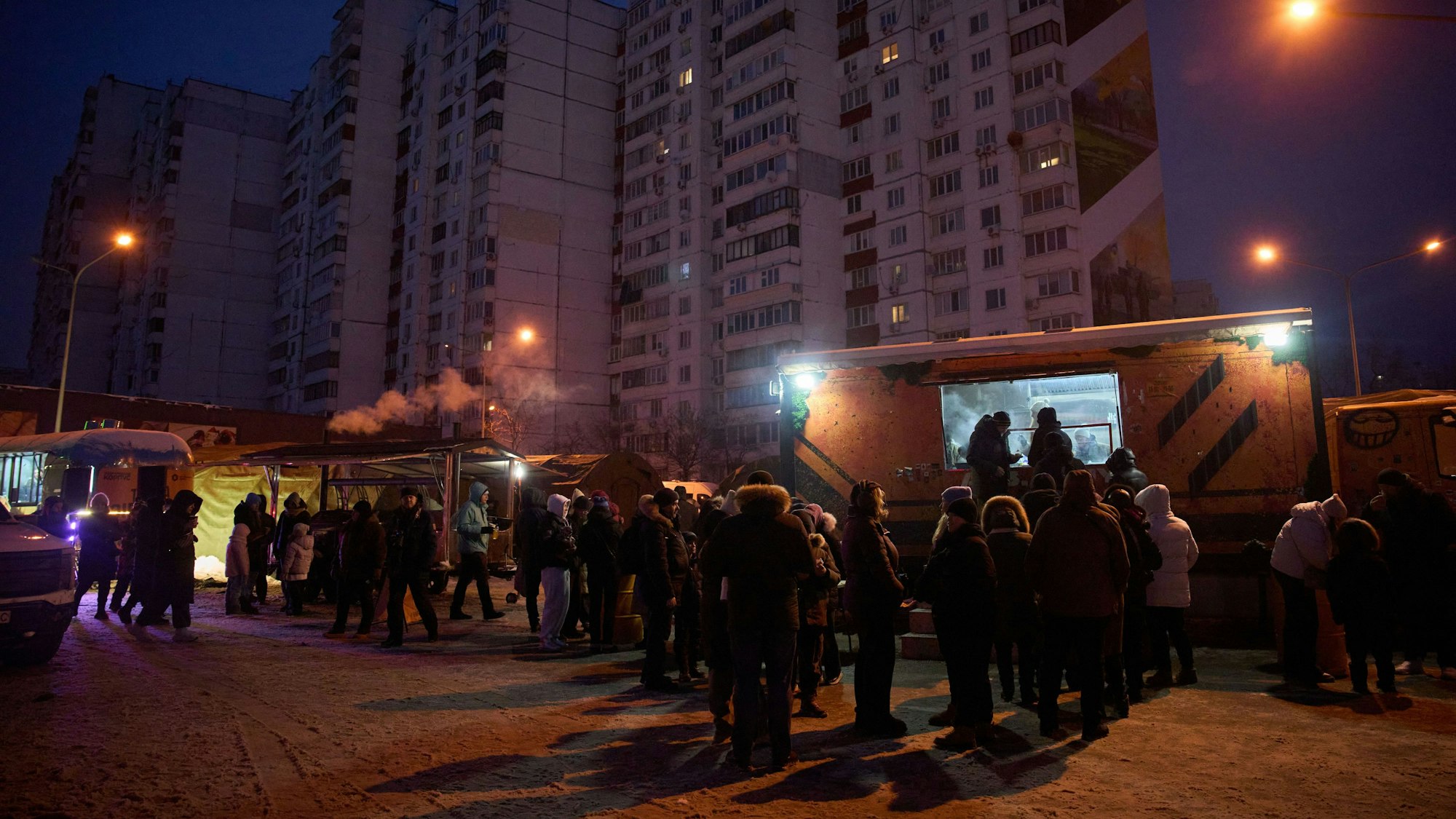 Menschen stehen in einer Schlange für kostenlose warme Mahlzeiten an, die Veteranen in einem Wohnviertel servieren. Russische Luftangriffe auf den Energiesektor des Landes lassen die Menschen im härtesten Winter seit Jahrzehnten ohne Strom, Heizung und Wasser zurück.