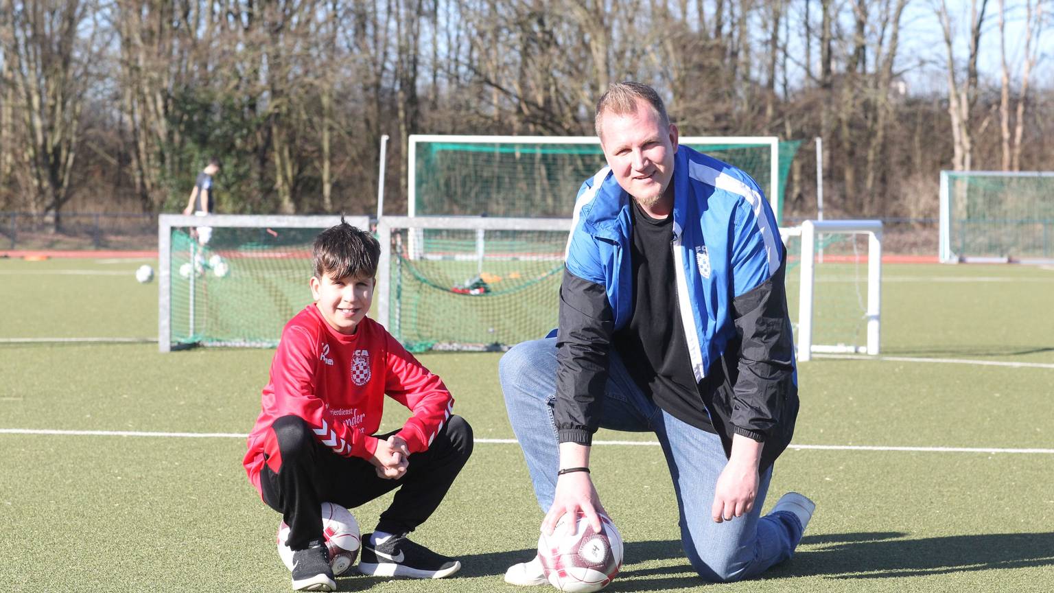 Elias Blum und sein Vater Jean-Marie Blum vor dem letzten Spiel des Sohnes am Samstag. Zu seinem Geburtstag darf er mit der U11 des FC Sankt Augustin gegen die U10 von Bayer Leverkusen und Borussia Dortmund kicken. Aus gesundheitlichen Gründen muss der Zehnjährige, der mit einem Herzfehler lebt, frühzeitig seine Karriere beenden.