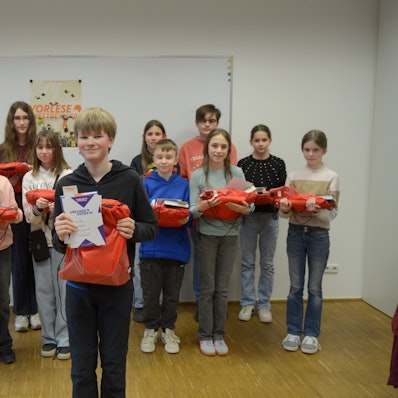 Aaron Seibt lacht in die Kamera, die anderen Teilnehmerinnen und Teilnehmer stehen in zwei Reihen hinter ihm. Alle haben ihre Preise in den Händen.