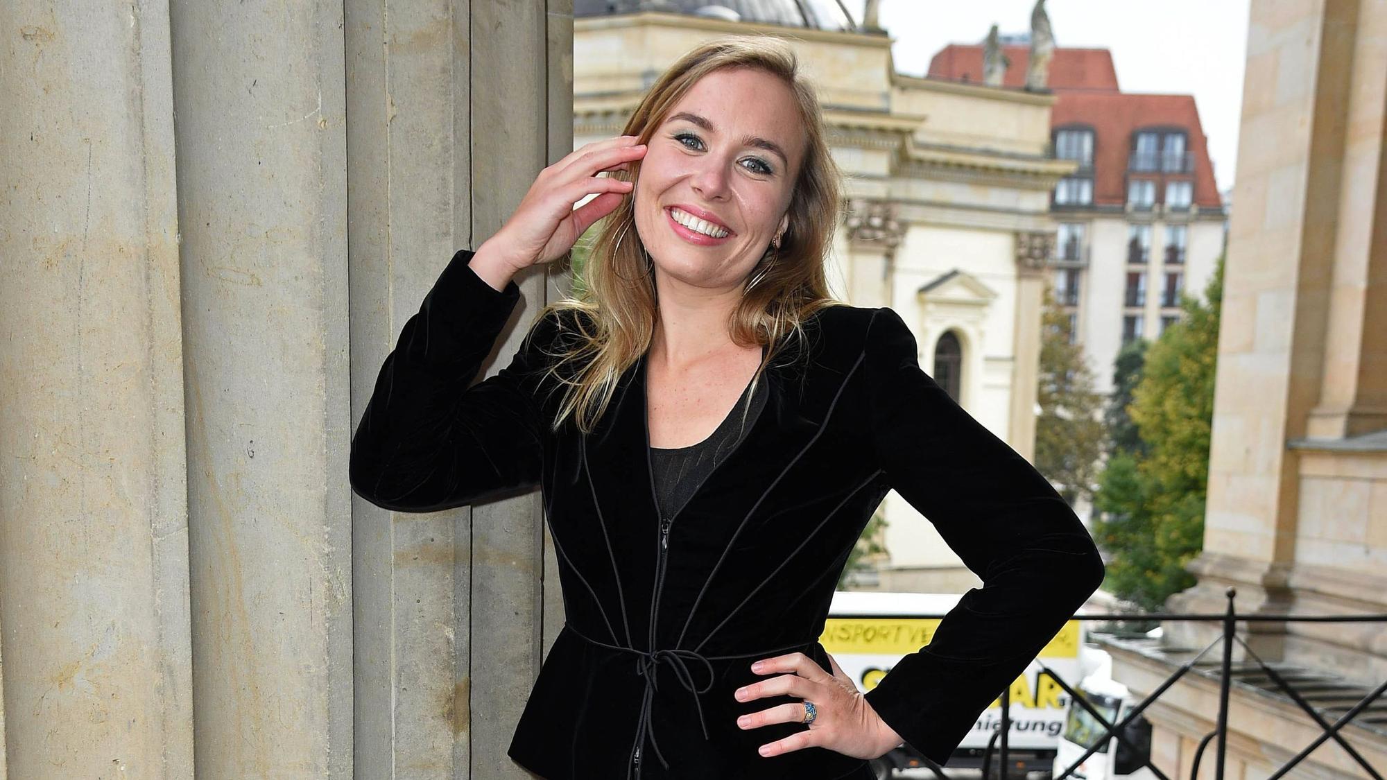 Eine blonde Frau lächelt in die Kamera.