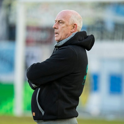 Mario Basler steht am Rande eines Fußballplatzes.