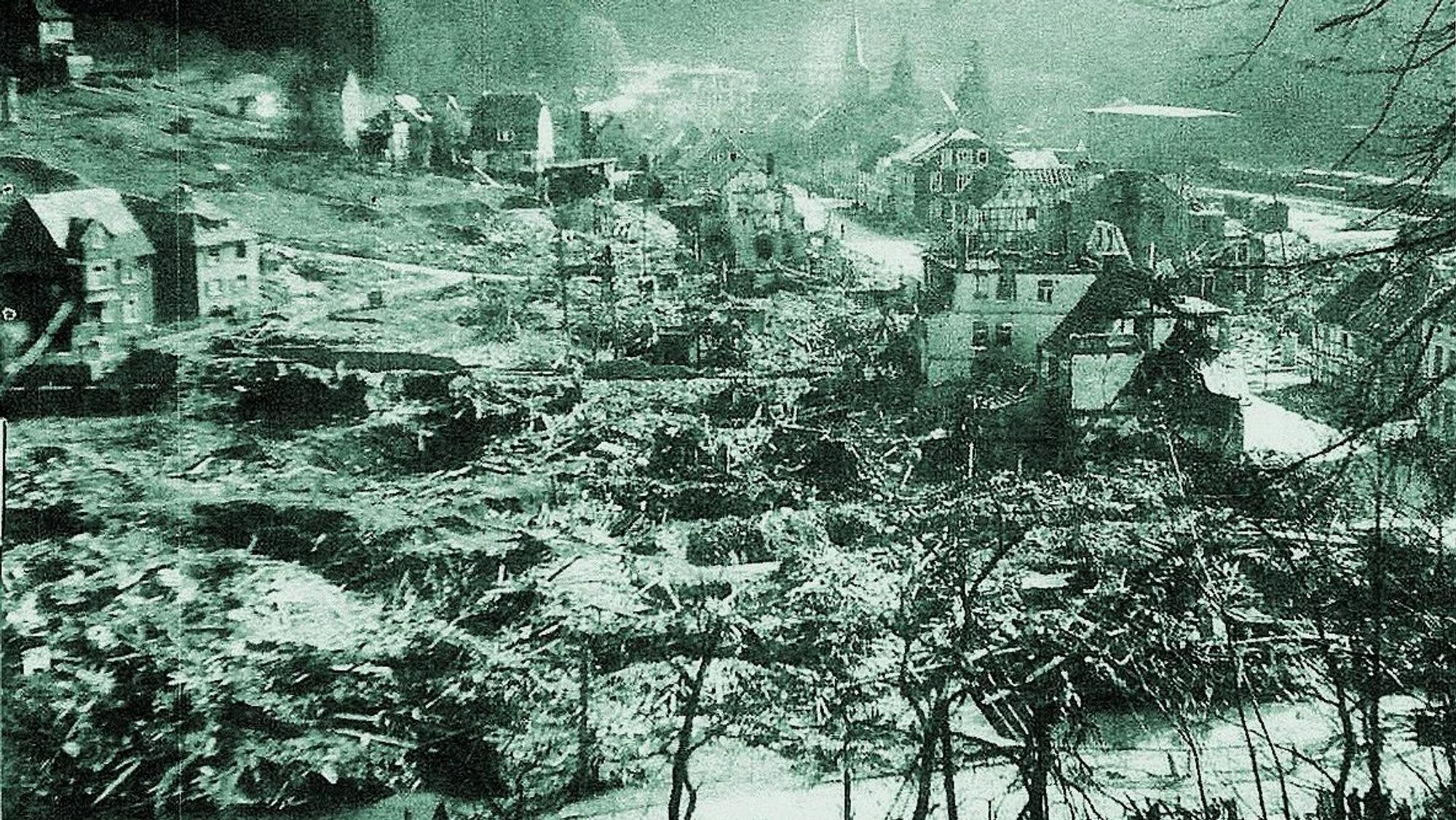 Ein altes Bild von Engelskirchen mit zerbombten und verwüsteten Häusern und Bäumen ist zu sehen. Der Schaden ist enorm.