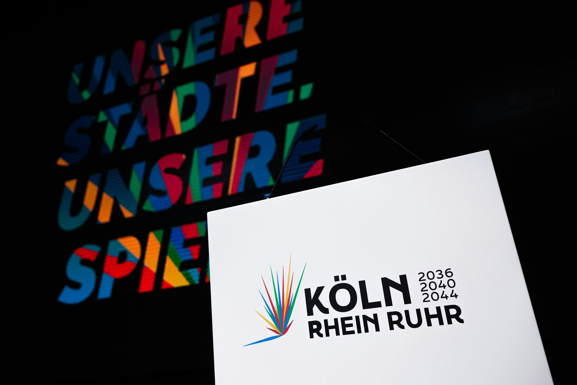 19.01.2026, Nordrhein-Westfalen, Köln: Das Logo ist beim Start der Kampagne für die Bewerbung der Region Rhein-Ruhr, mit Köln als "Leading City", um Olympische und Paralympische Spiele in der Lanxess-Arena zu sehen. Foto: Rolf Vennenbernd/dpa +++ dpa-Bildfunk +++
