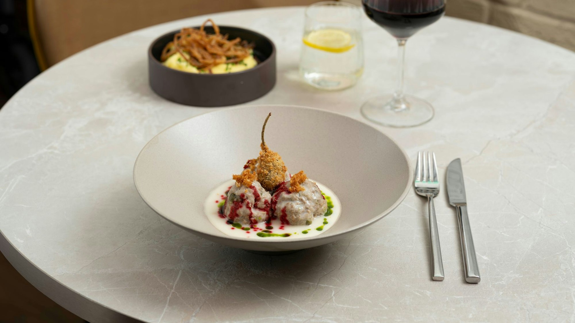 Der frittierte Kapernapfel und die Tröpfchen von dem eingekochten Rote-Bete-Sirup geben den Königsberger Klopsen zusätzlich Textur sowie Crunch und sorgen für ein Spiel mit Säure-Nuancen.