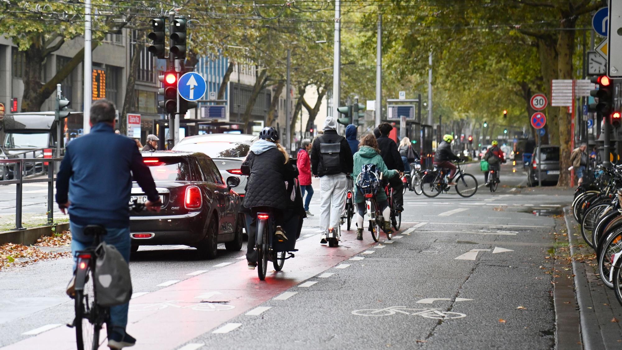 Radfahrende auf den Kölner Ringen. Dort ist eine ehemalige Autospur für Radfahrer freigegeben, ohne bauliche Abtrennung vom Autoverkehr.
