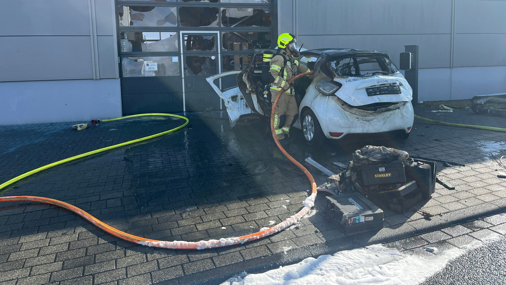 In Sankt Augustin-Menden ist ein E-Auto in Flammen aufgegangen. Die Löscharbeiten gestalteten sich aufwendig, das ausgebrannte Fahrzeug wurde schließlich in eine Mulde gezogen, die geflutet wurde.