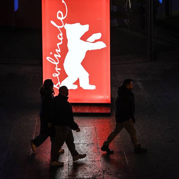 Passanten gehen am Abend der Preisverleihung an einem Berlinale-Plakat vorbei.