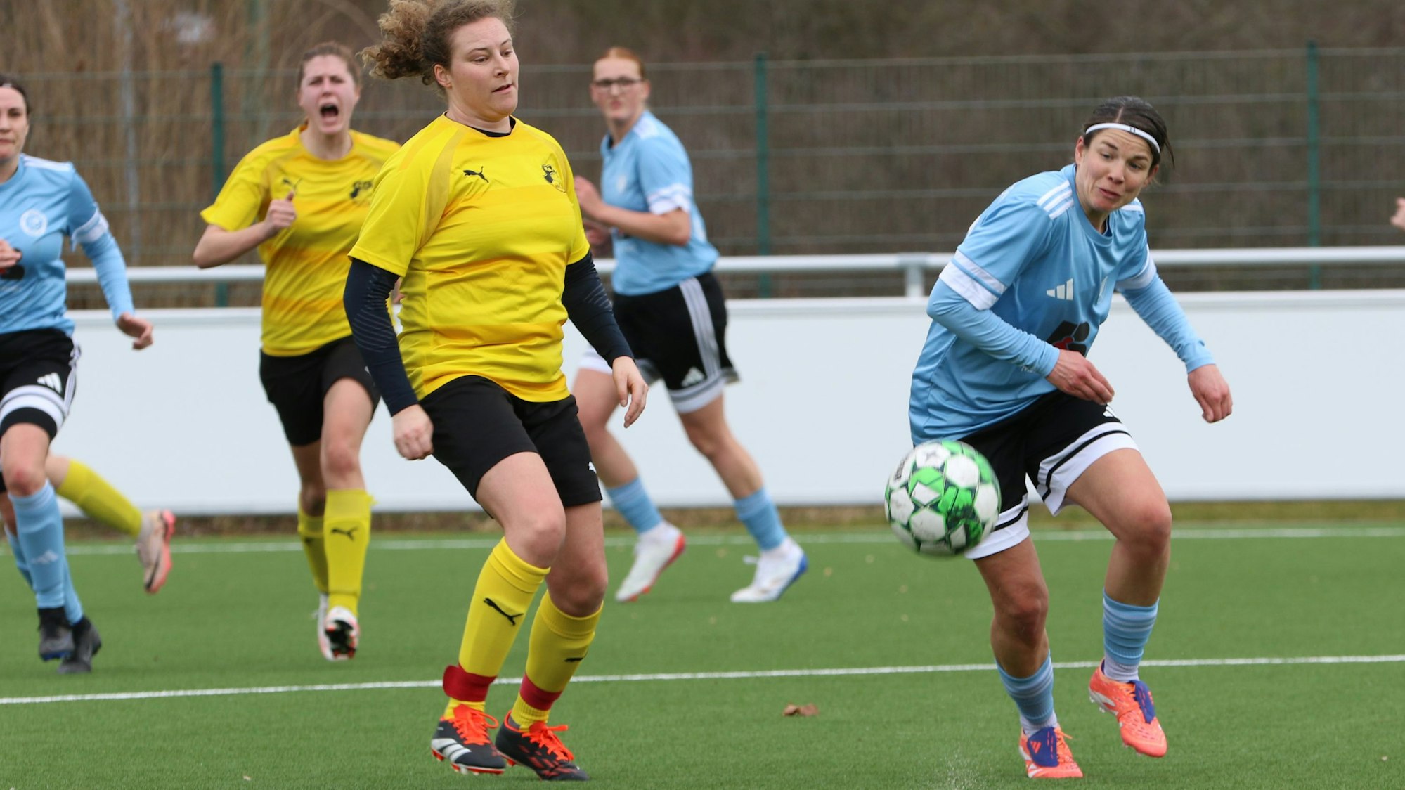 Stefanie Möseler versucht den Ball unter Kontrolle zu bekommen. Eine Gegenspielerin beäugt sie kritisch.