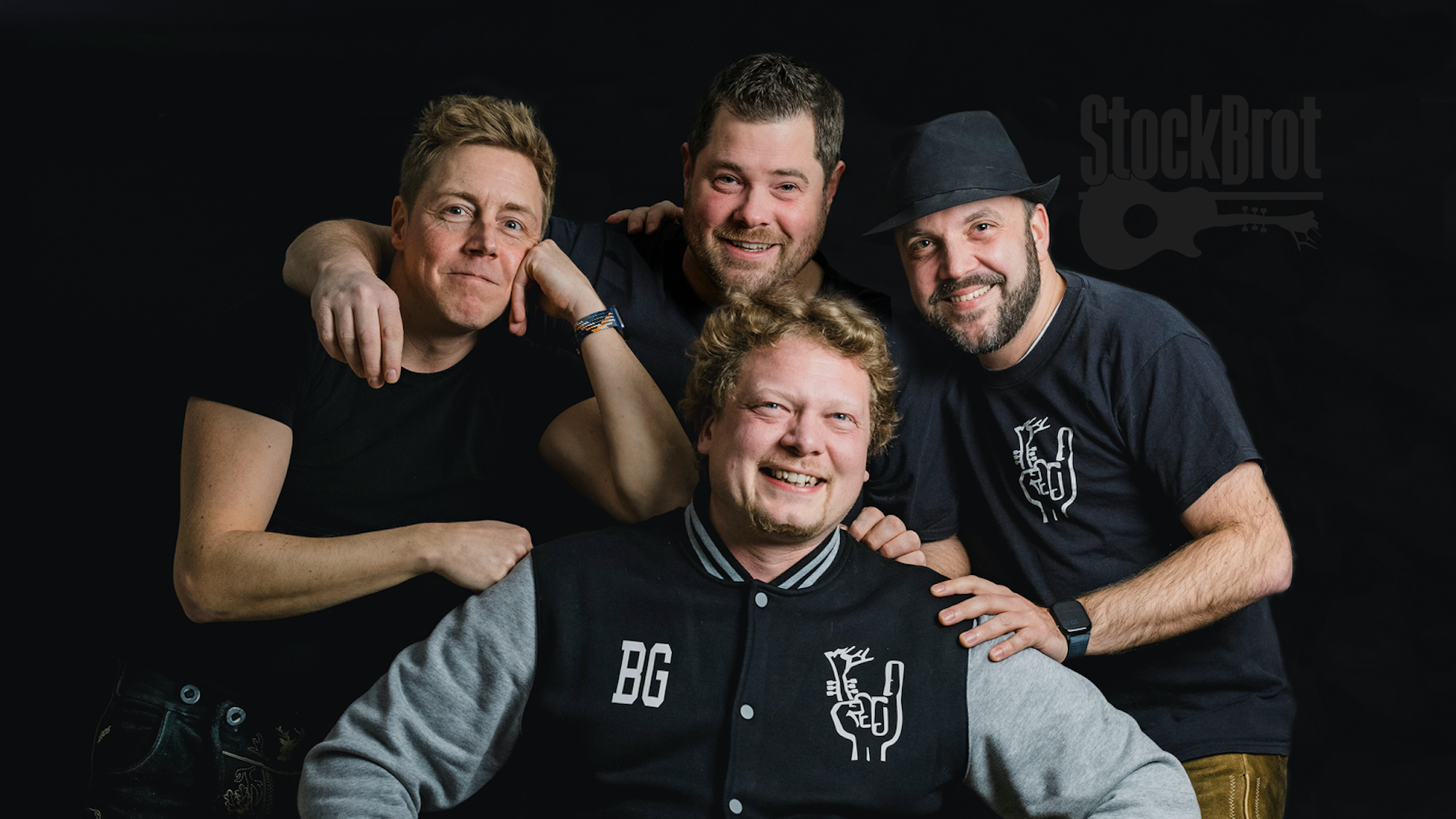 Vier Männer lachen in die Kamera.