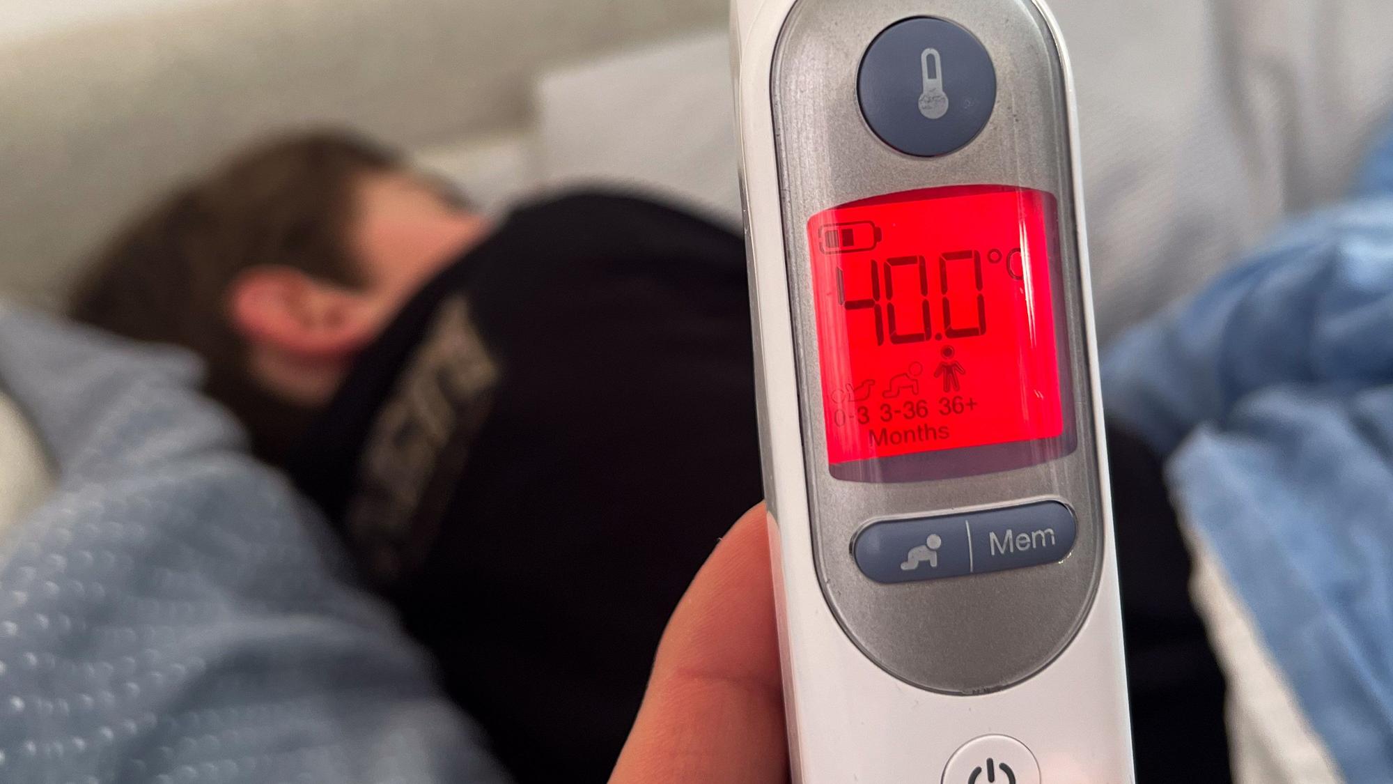 Ein Fieberthermometer zeigt eine Körpertemperatur von 40,0 Grad nach der Messung bei einem mit Influenza infizierten Kind an. (Symbolbild)