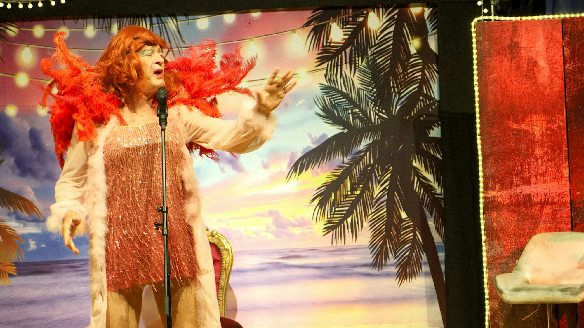 Gerhardt trägt ein Kleid und eine Perücke.