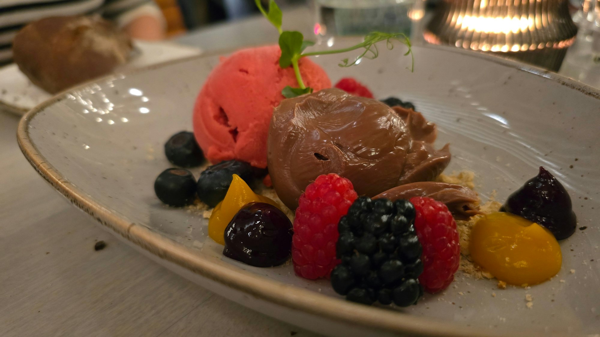 Teller mit Eiskugeln und Beeren ist zu sehen.