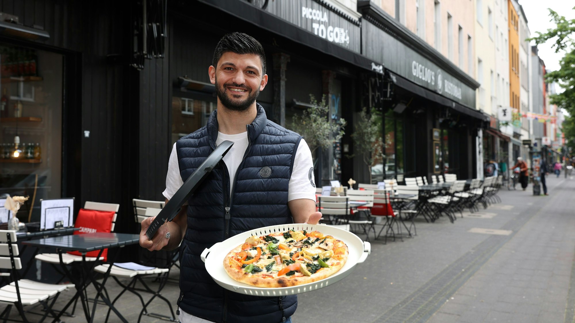 Pizzeria Piccola in Ehrenfeld bietet ihre Pizza im Mehrwegbehälter von der Firma Vytal an, Davide Giglio von der Pizzaria Piccola zeigt sie. (Archiv)