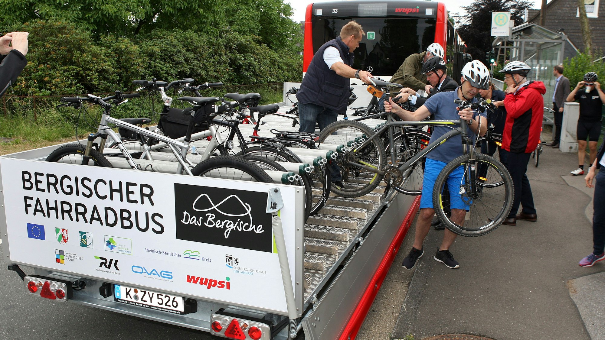 Menschen laden Fahrräder vom Anhänger eines Bergischen Fahrradbusses in Wermelskirchen.