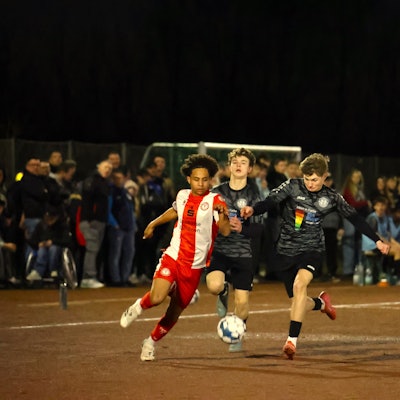 Laufduell zwischen einem Kölner und einem JSG-Spieler unweit der Außenlinie. Ein weiterer JSG-Spieler kommt nicht hinterher.