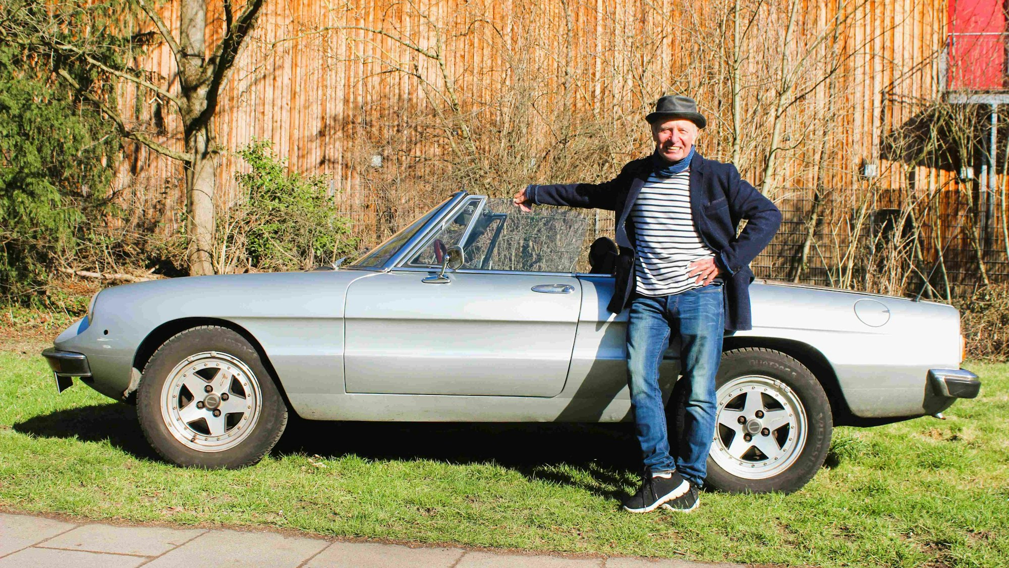 Das Bild zeigt Didi Jünemann vor seinem Alfa Romeo Spider.