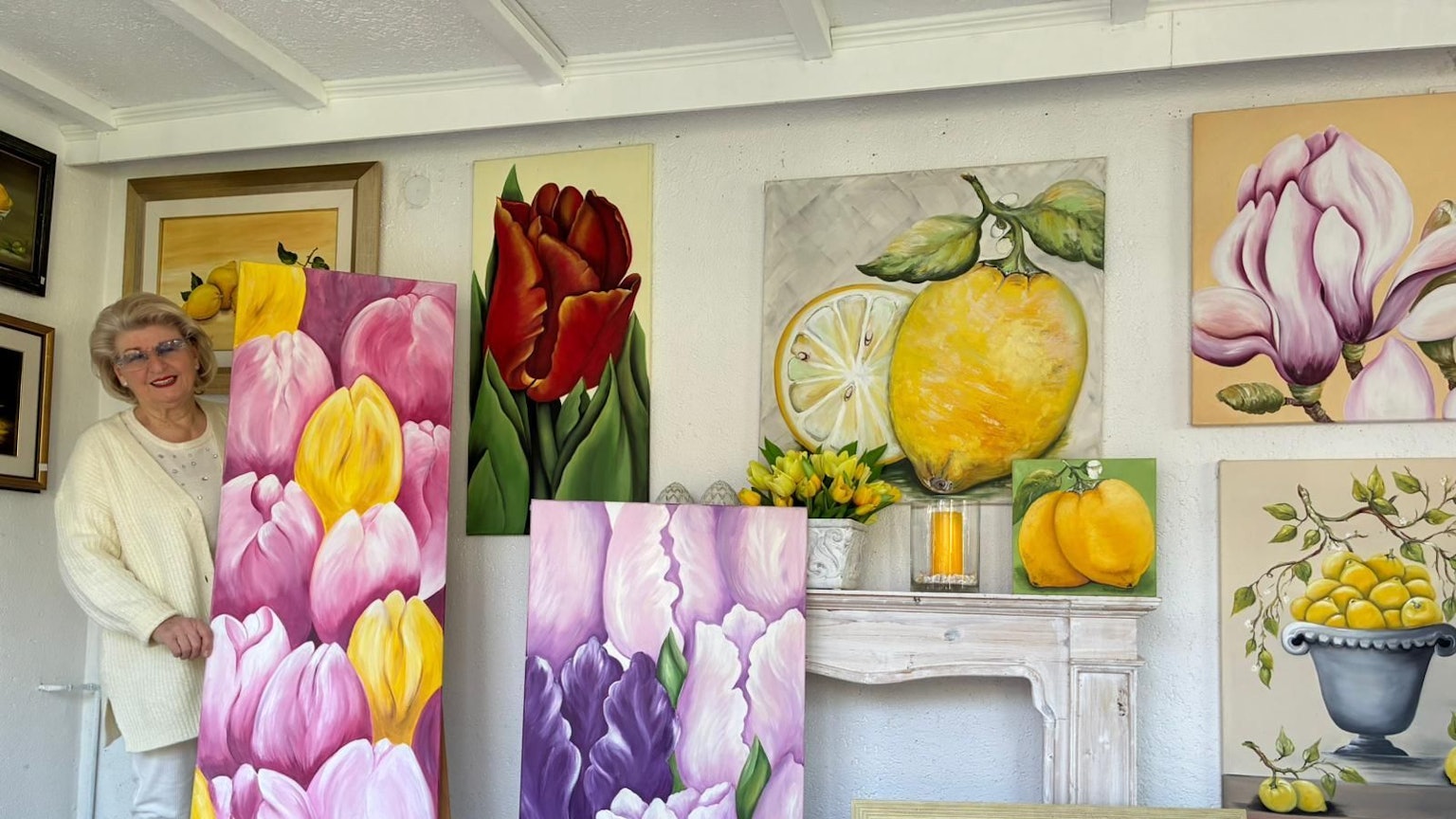 Ellis Paustenbach steht hinter einem Gemälde, das Tulpen zeigt.