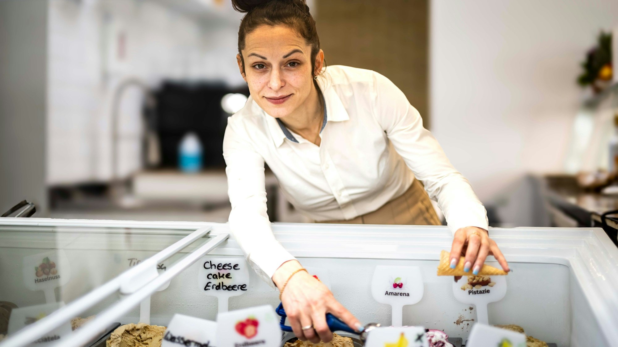 Das Bild zeigt die Chefin des Eiscafé an der Eistheke.
