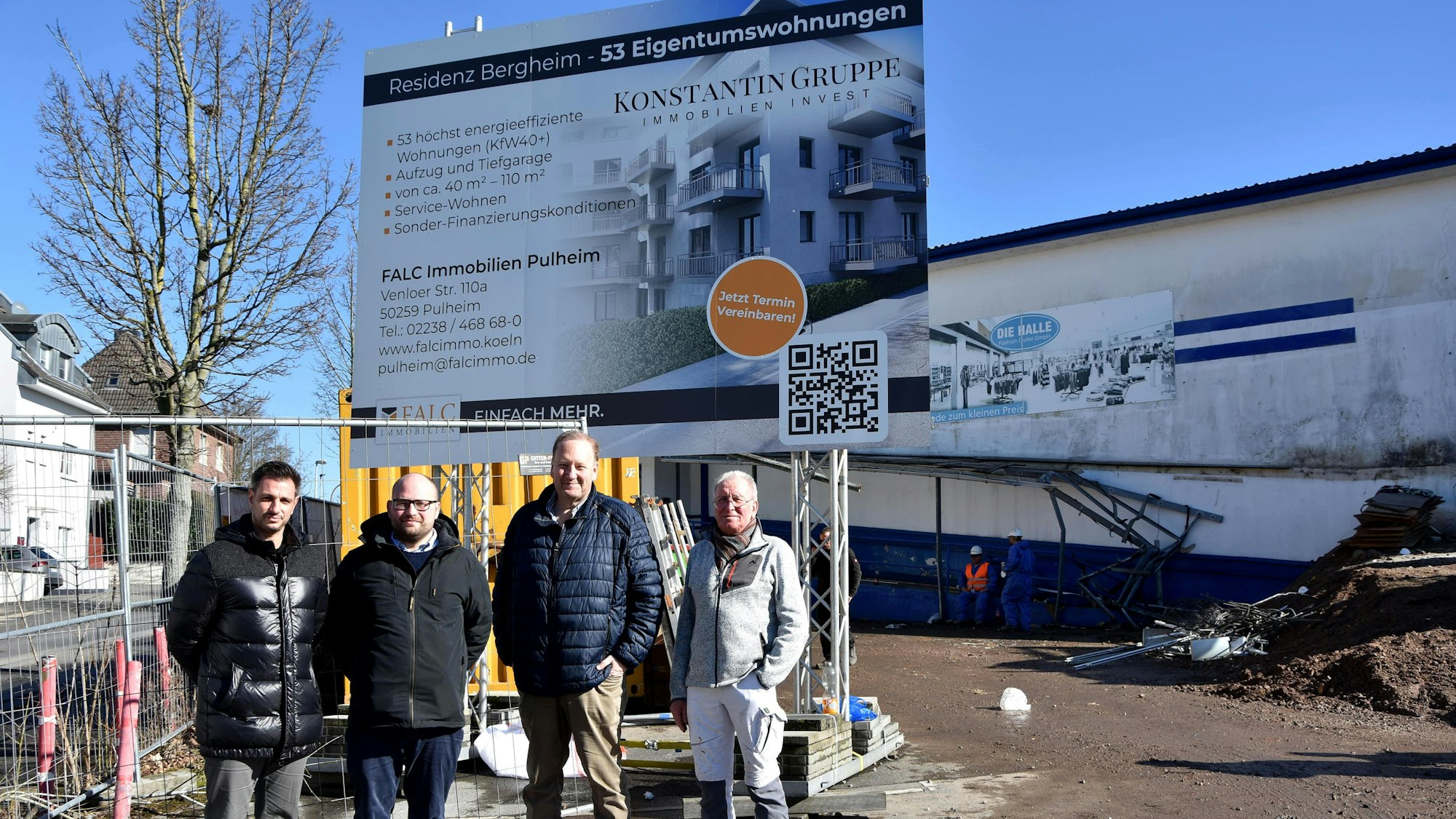 Zu sehen sind vier Männer vor einer Baustelle.