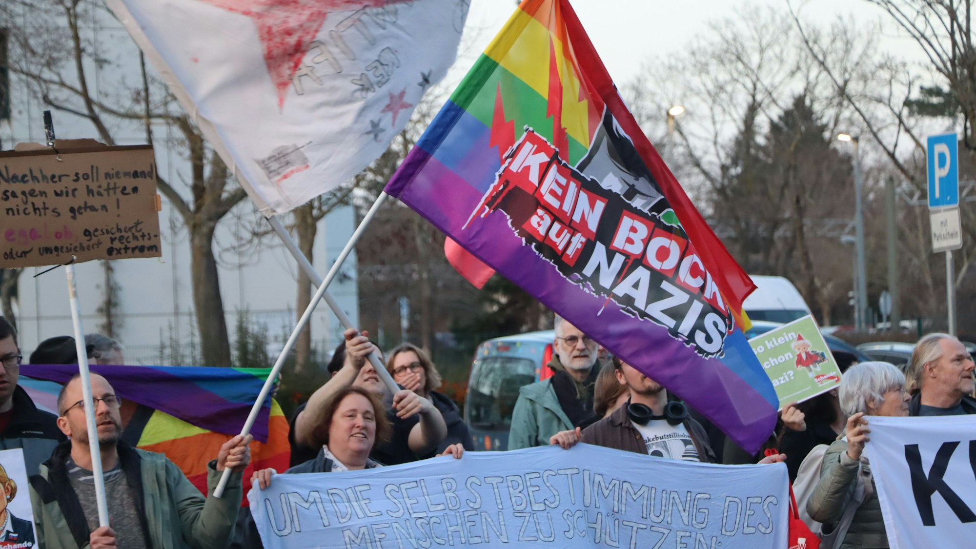 Zu sehen sind Demonstranten mit bunten Bannern.