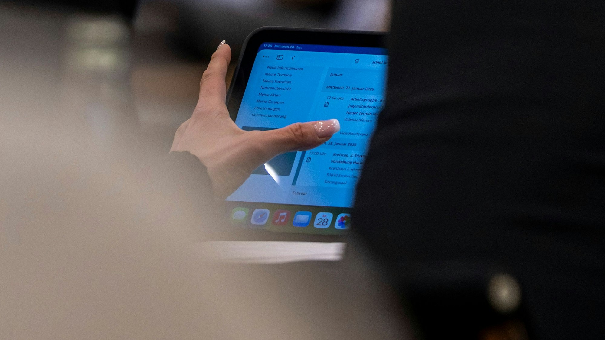 Das Bild zeigt ein Mitglied des Kreistags vor seinem Ipad. Dort ist die Tagesordnung der Sitzung hinterlegt.