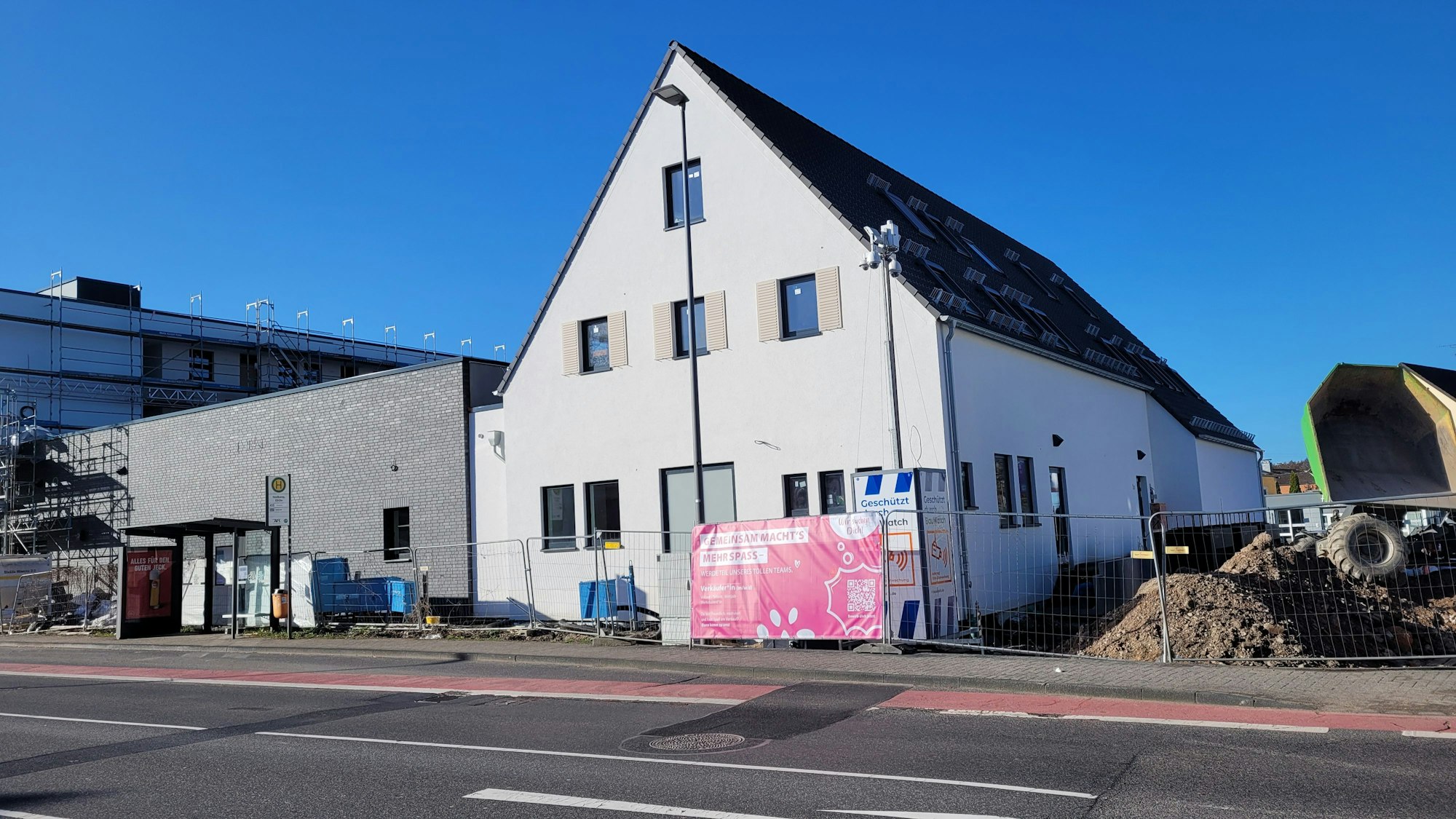 Ein Neubau mit Giebeldach, daneben Erdhaufen.