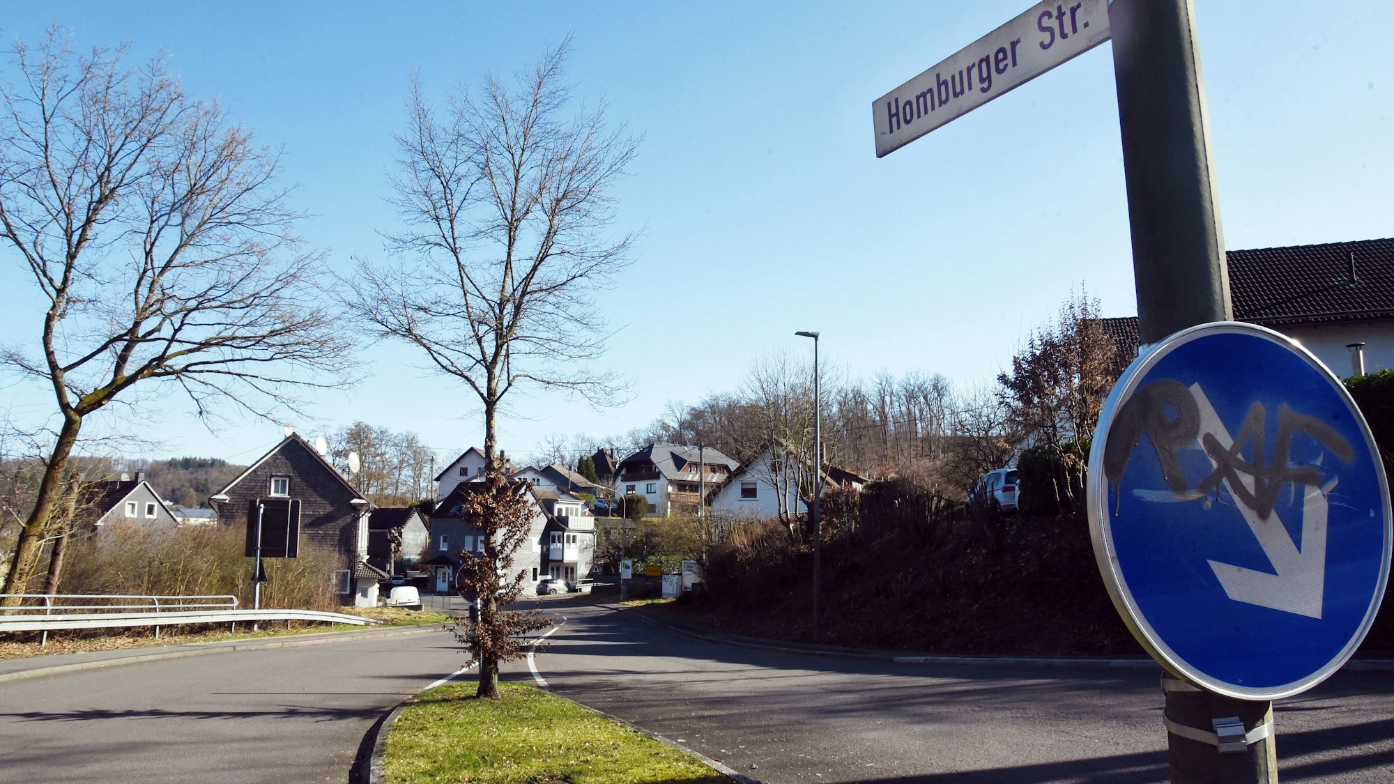 Einen Straßenschild und eine leere Fahrbahn.